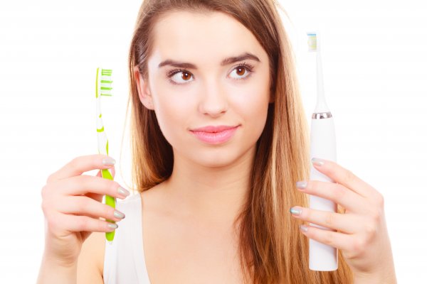 Woman holding two toothbrushes